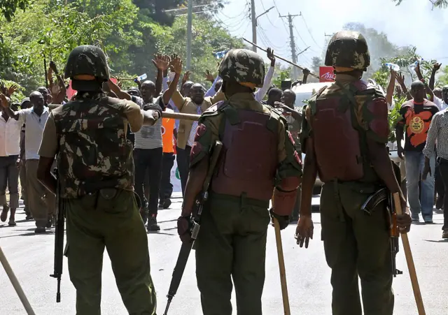 Police officers stand guard on June 06, 2016 in Kisumu, during demonstrations led by the Coalition for Reforms and Democracy (CORD's) opposition party, demanding the national electoral oversight body, the Independent Electoral and Boundaries Commission (IEBC), disband the electoral body