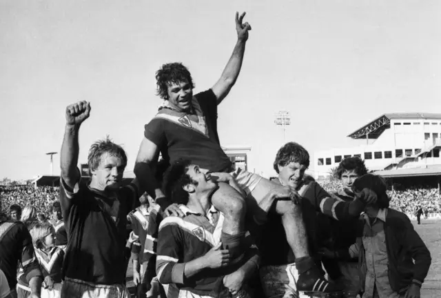 Artie Beetson is lifted high by the Roosters players after their 1974 triumph