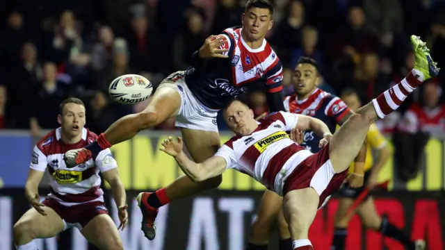 Joseph Manu of Sydney Roosters competes with Dan Sarginson of Wigan Warriors