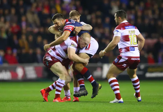 James Tedesco of Sydney Roosters is tackled by Liam Farrell of Wigan Warriors