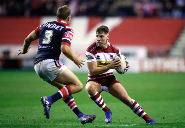 Wigan Warriors' George Williams runs at Sydney Roosters' Mitchell Aubusson