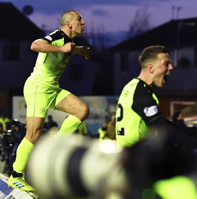 Scott Brown climbs over the hoardings to celebrate with the Celtic fans