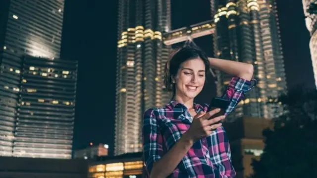 A woman looking at her phone in Kuala Lumpur, Malaysia