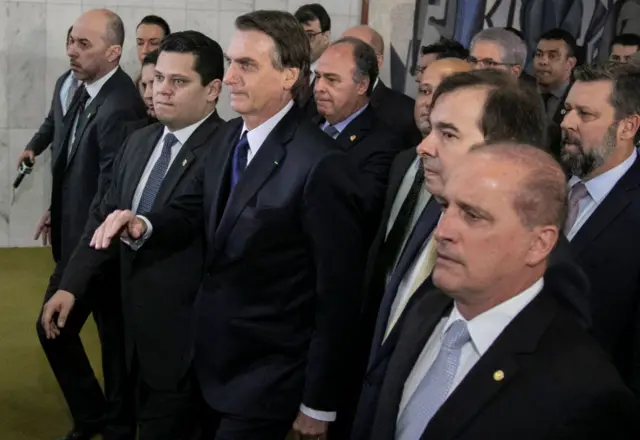 Brazil's President Jair Bolsonaro (C) accompanied by members of his government, arrives at the National Congress in Brasilia to hand over a draft of a pension reform bill