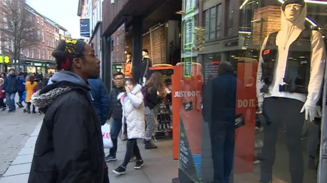 Damien Henry looking into shop window