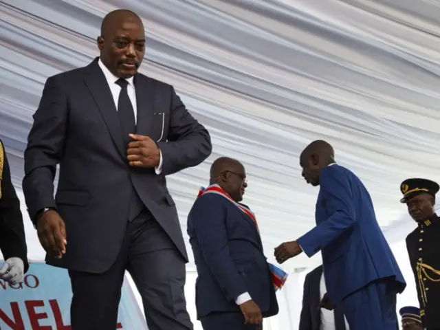 Joseph Kabila (L) walks off as the new President Felix Tshisekedi (2-R) remains on the stage