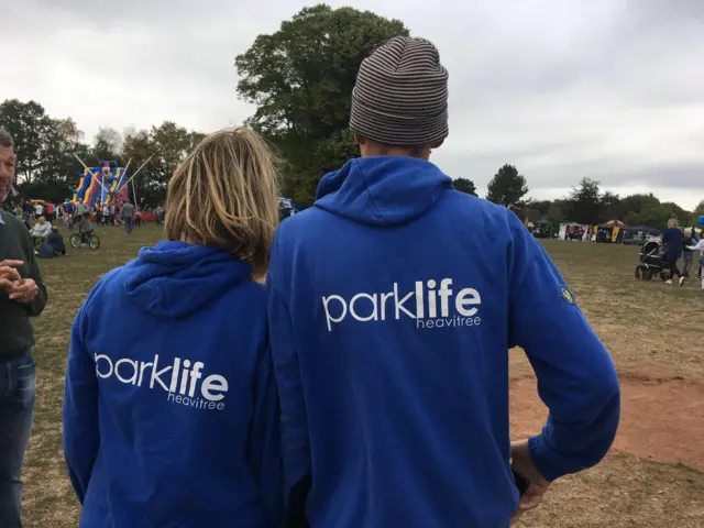 Man and woman wearing 'Park Life Heavitree' hoodies