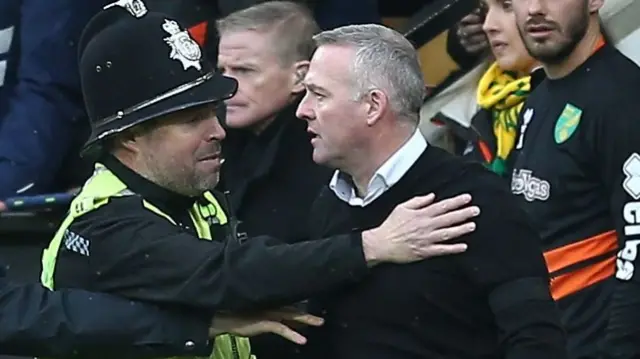 Paul Lambert is held back by a police officer