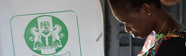 A woman voting in a booth in Nigeria