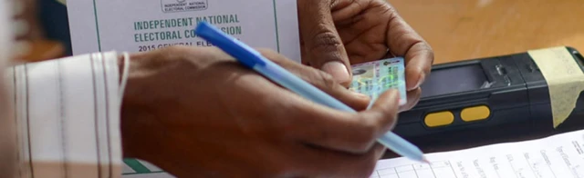 A Nigerian electoral official checking a voter card