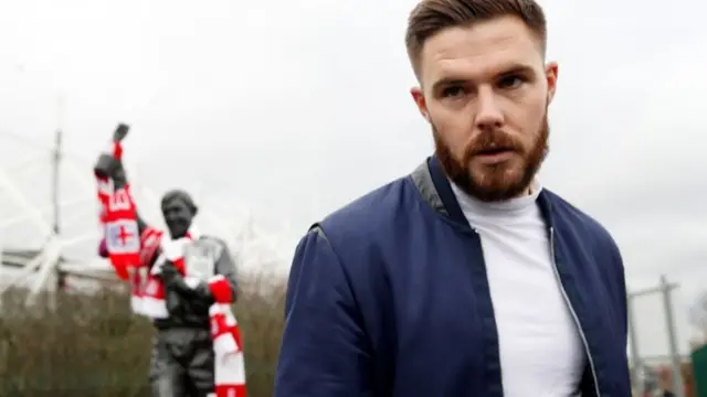 Jack Butland next to the Gordon Banks statue at Stoke City