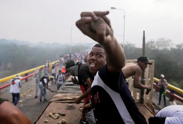 Opposition supporters clash with Venezuela's security forces at a bridge on the border of Colombia