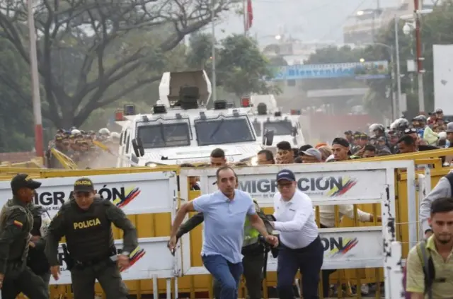 Two armoured vehicles cross a bridge in Venezuela to Colombia