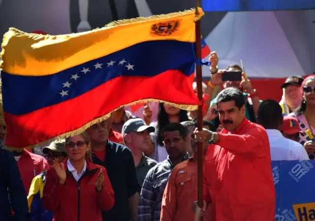 Venezuelan President Nicolás Maduro waves the national flag during a pro-government march in Caracas