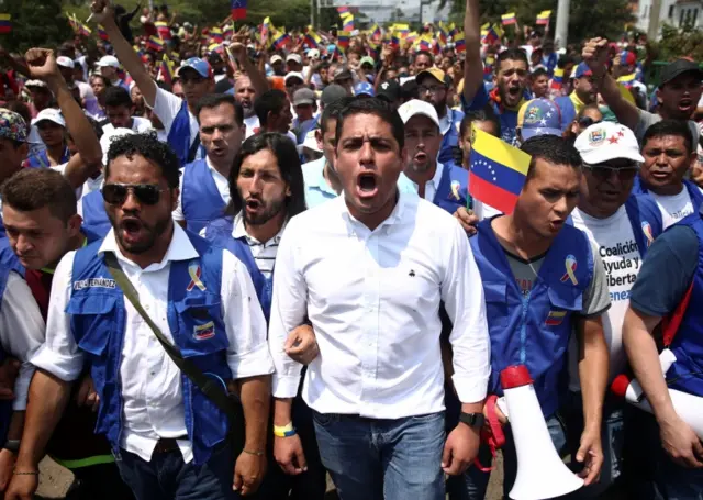 Venezuelan opposition politicians and their supporters march towards he Simón Bolívar bridge