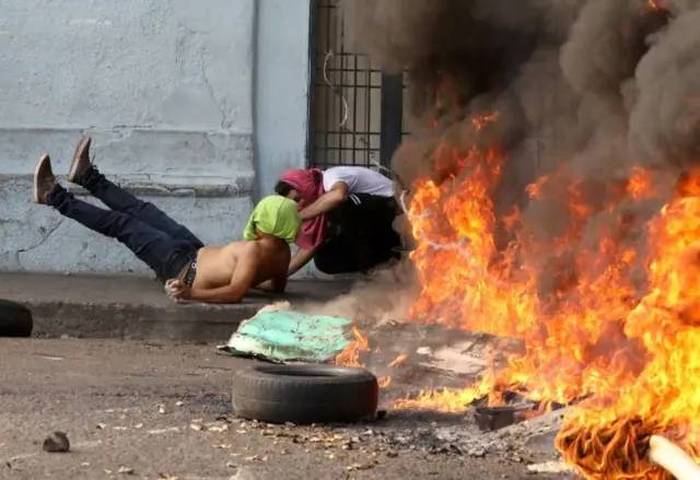 A protester runs into barbed wire on the streets of Ureña