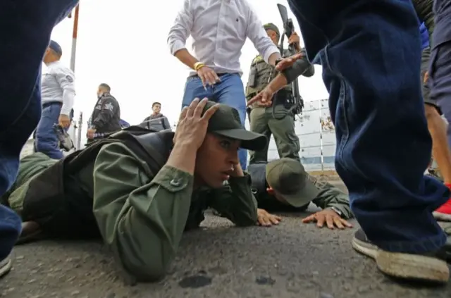 Venezuelan soldiers are detained by Colombian police after crossing the border to Cucuta