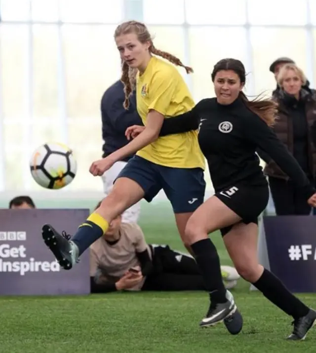 two female players in the middle of a 5-a-side game