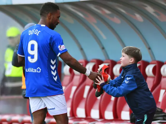 Jermain Defoe gives a young fan his football boots