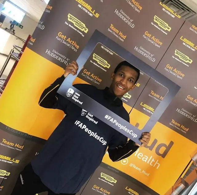 young male referee holding up a frame with #FAPeoplesCup branding on it