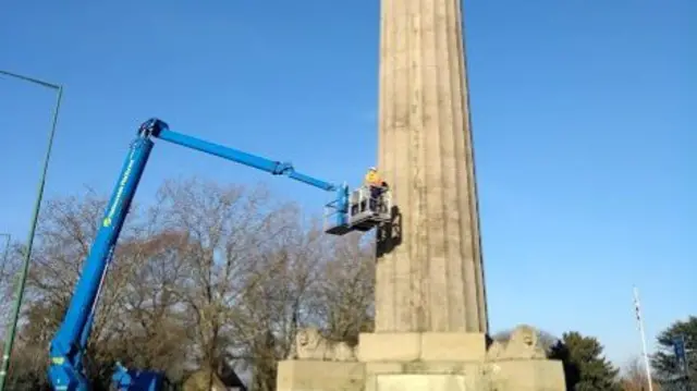 Stonemasons inspecting the column