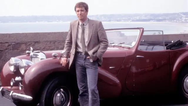 Actor John Nettles leaning on a car