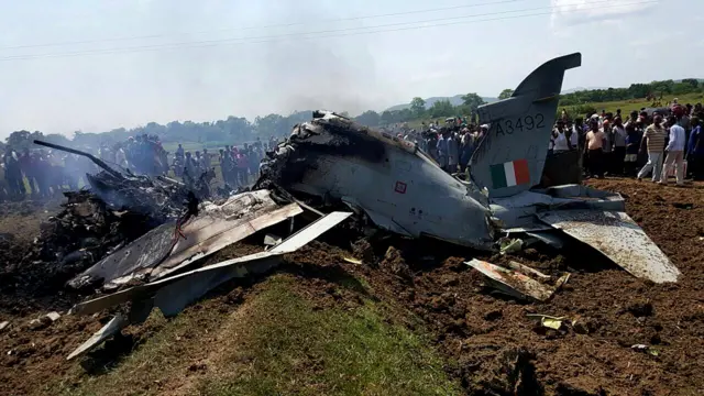 Onlookers look at an Indian Air Force advanced jet trainer aircraft (A 3492) which crashed in a paddy field at Kudurasahi in Mayurbhanj district, some 365 kms north of Bhubaneswar on 3 June 2015