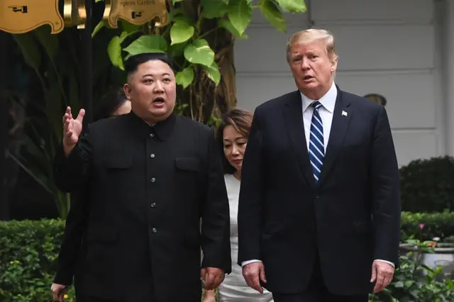 US President Donald Trump (R) walks with North Korea"s leader Kim Jong Un