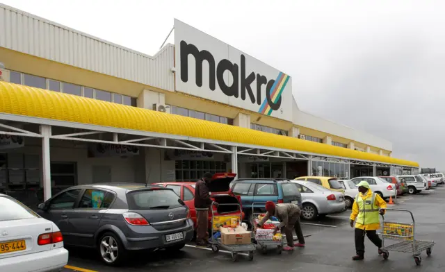 Shoppers load their goods outside a Makro branch of South African retailer Massmart in Cape Town.