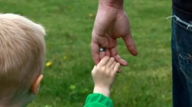 Child and adult holding hands