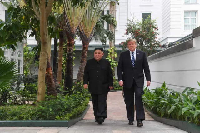 US President Donald Trump (R) walks with North Korea"s leader Kim Jong Un