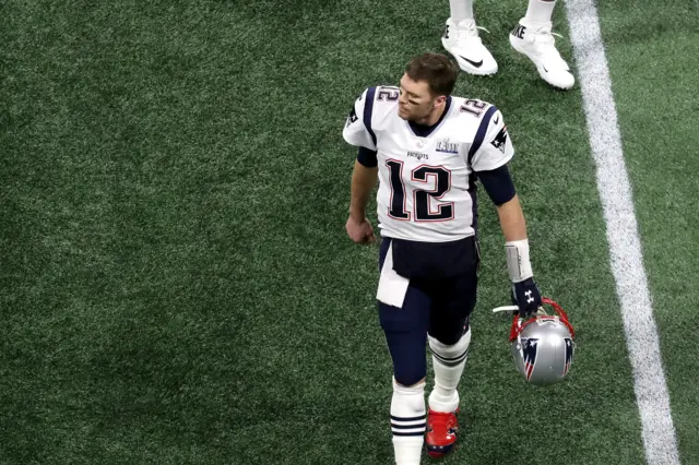 Tom Brady walks off after being intercepted