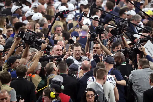 Tom Brady is surrounded by the media