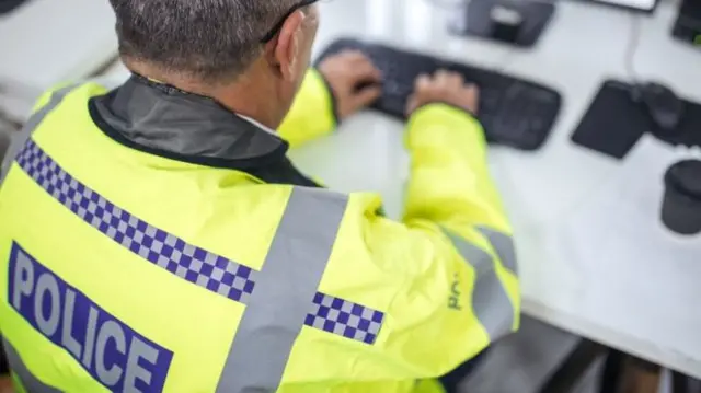 A police officer at a computer