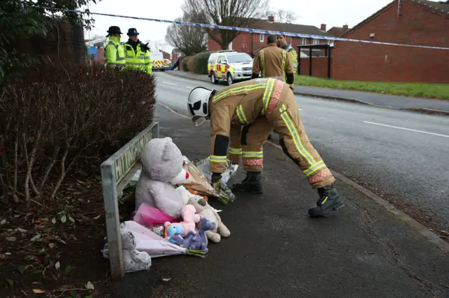 Fire officer leaving flowers at scene of fire