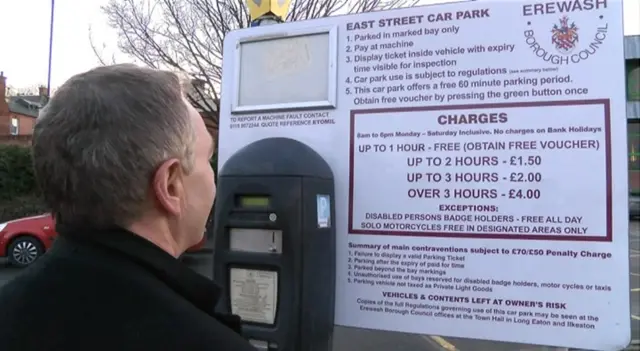 A man views the parking charges