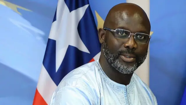 Liberia's President George Weah pictured in front of a Liberian flag