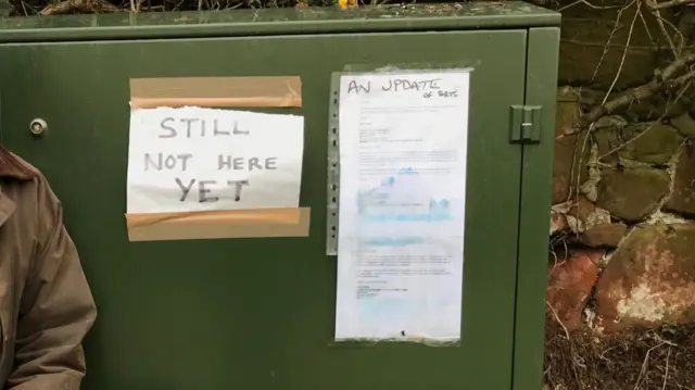 The broadband cabinet with complaining notes taped to it