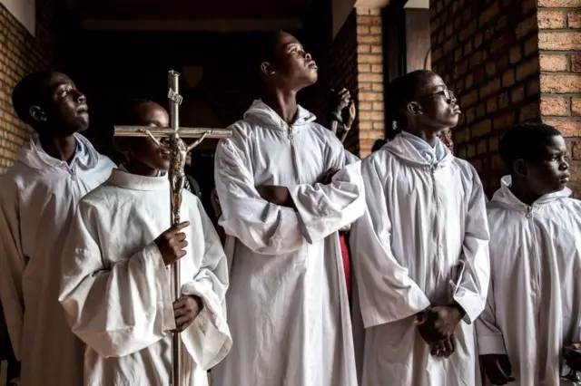 altar boys craning their necks to catch a glimpse of the Democratic Republic of Congo's President Felix Tshisekedi before a memorial service for his father, Etienne Tshisekedi, in Kinshasa