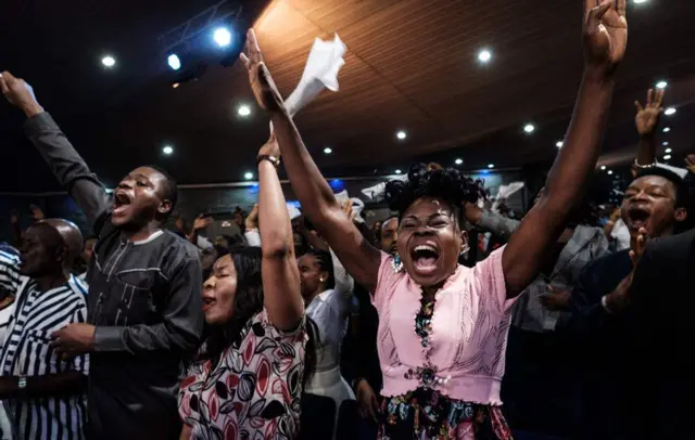 Woman raising her arms at a church service