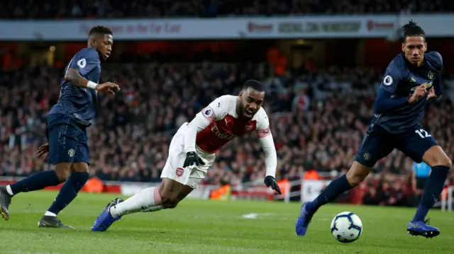 Alexandre Lacazette goes down after a challenge from Fred