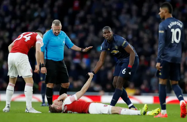 Paul Pogba shakes the hand of injured Aaron Ramsey