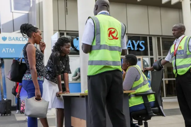 Relatives talk to airport staff at a help desk set up to give information about the airline