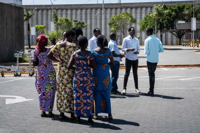 People gather at the Jomo Kenyatta International Airport in Nairobi, Kenya as they wait for information about the crashed airline