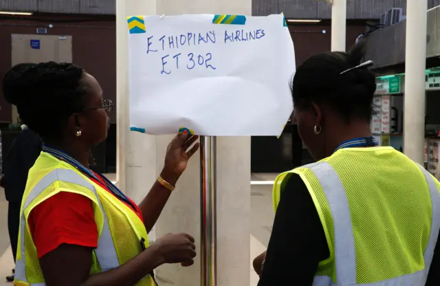 Kenya Airports Authority (KAA) workers hang an information notice of Ethiopian Airlines Flight ET 302, at the Jomo Kenyatta International Airport