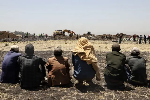 People stand near collected debris at the crash site of Ethiopia Airlines near Bishoftu, a town some 60 kilometres southeast of Addis Ababa, Ethiopia, on March 11, 2019.