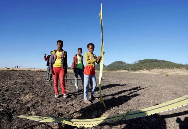 Local residents collect debris at the scene where Ethiopian Airlines Flight 302 crashed in a wheat field just outside the town of Bishoftu, 62 kilometers southeast of Addis Ababa on March 10, 2019 in Addis Ababa, Ethiopia