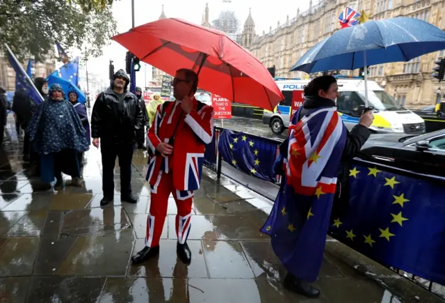 Demonstrators in the rain outside Parliament