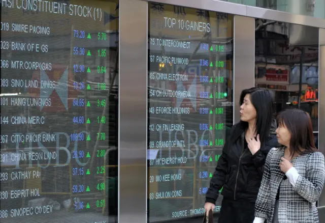 People look at stock boards in Hong Kong