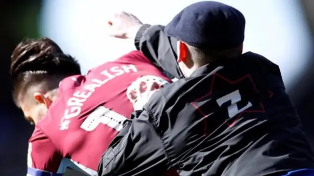 Jack Grealish is attacked from behind by a man wearing a Birmingham City jacket